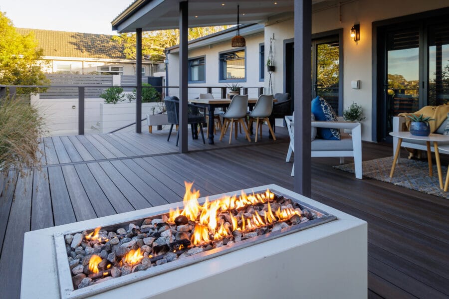 Modern South African outdoor patio with comfortable seating, a fire pit, and lush indigenous water-wise landscaping
